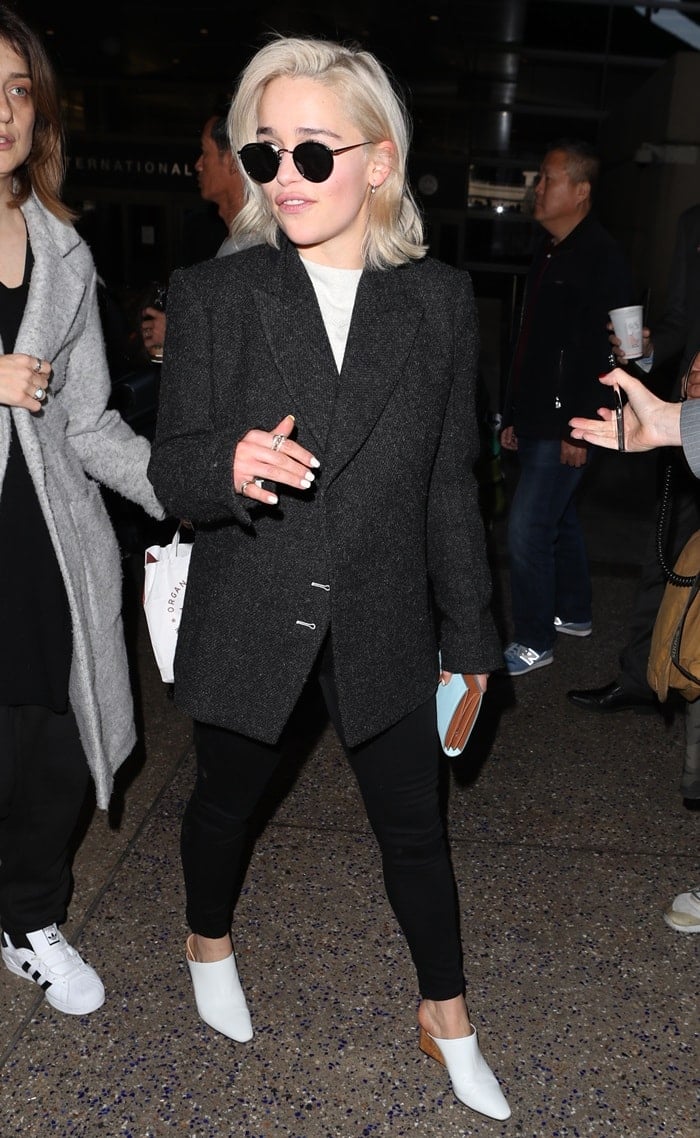 Emilia Clarke arriving at LAX airport in a black jacket and tight leggings