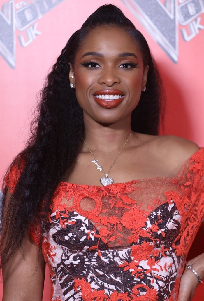 Jennifer Hudson wearing an orange, black, and white off-the-shoulder lace dress from the Vivienne Westwood Spring 2016 Collection