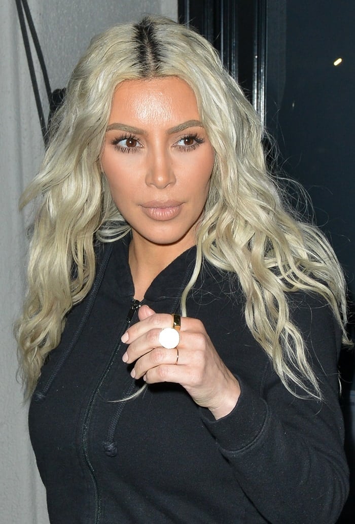 Kim Kardashian showing off her long platinum hair center parted and in waves