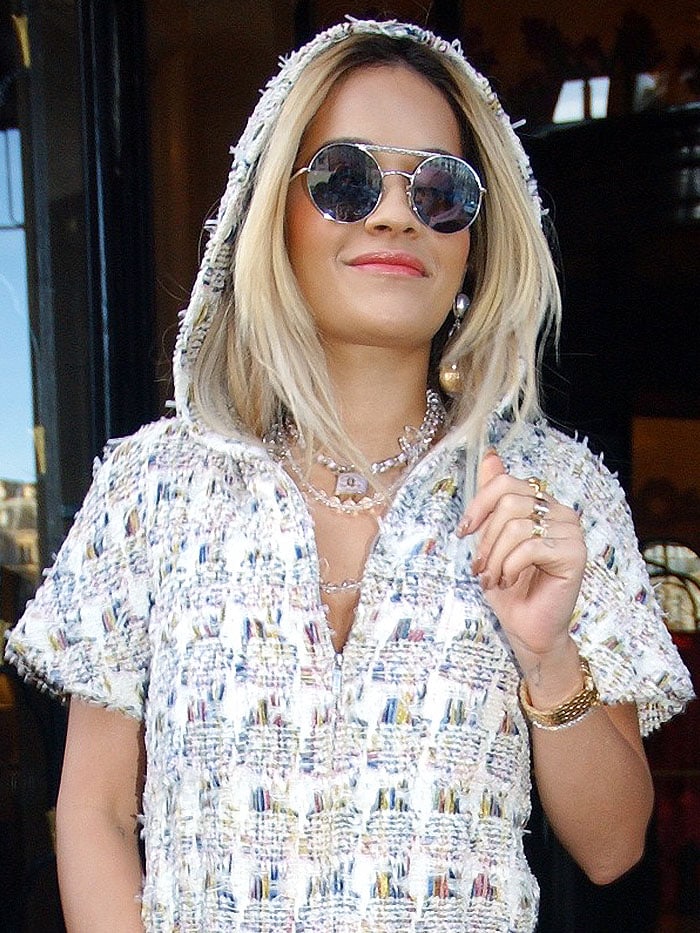 Rita Ora accessorized her look with round silver sunglasses and layered padlock-pendant necklaces
