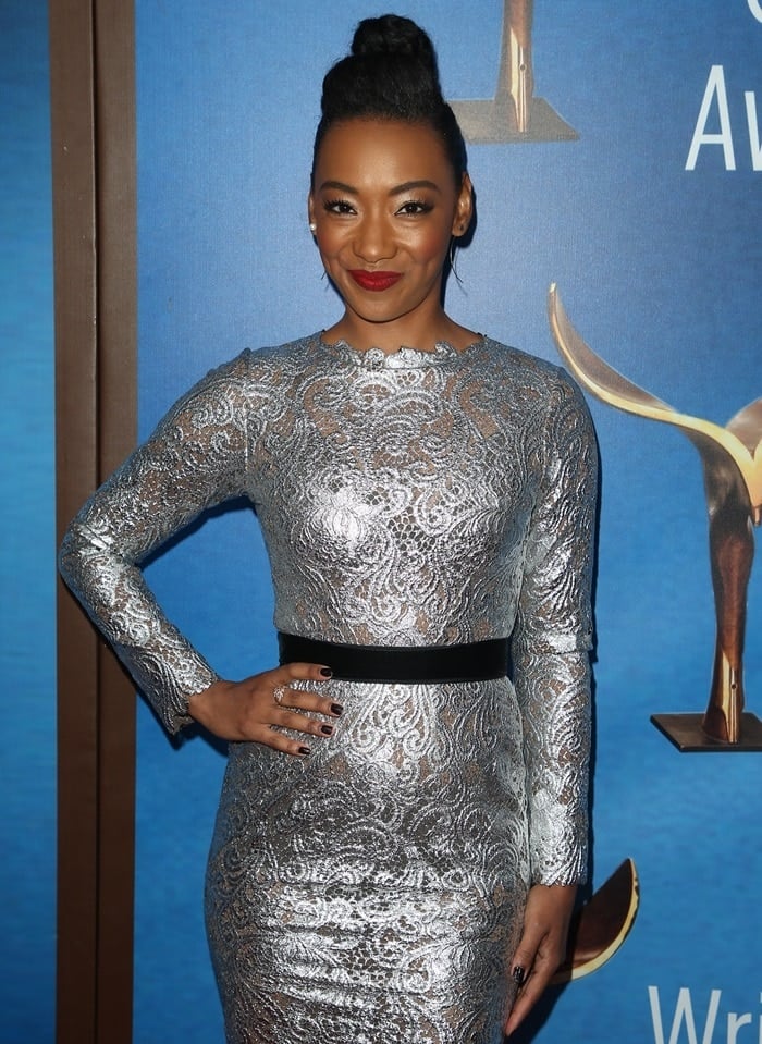 Betty Gabriel in a silver long sleeve floral lace dress from the Anaya Fall 2017 collection at the 2018 Writers Guild Awards at The Beverly Hilton Hotel in Beverly Hills, California, on February 11, 2018