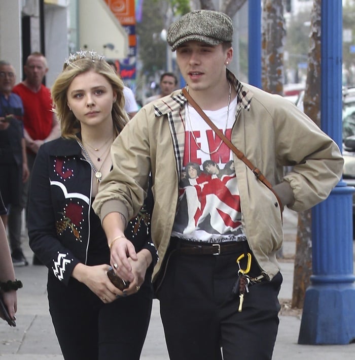 Brooklyn Beckham also looked every inch the trendsetter in ankle grazer pants, a rock-inspired t-shirt, and a dapper baker boy hat