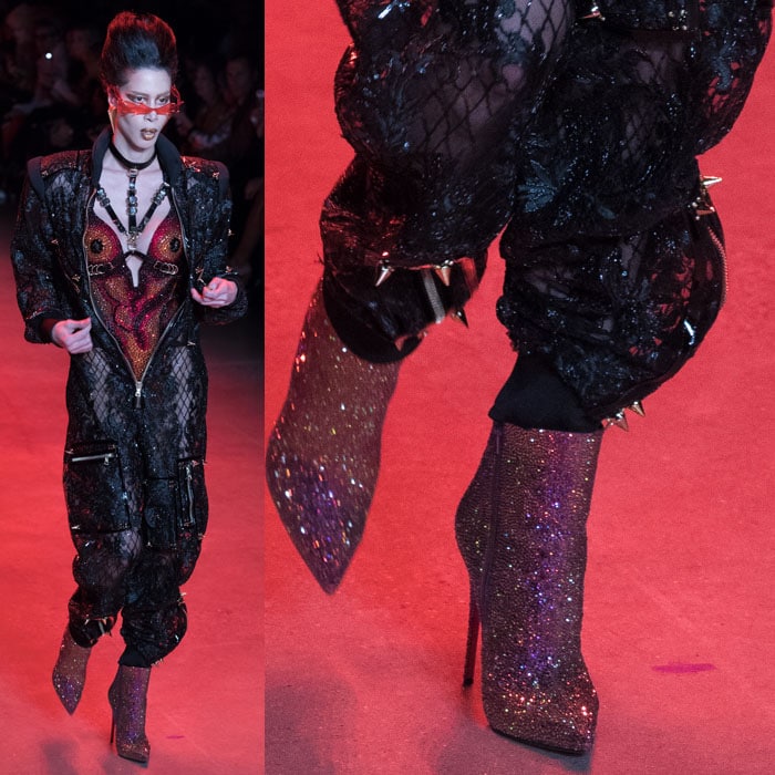 A model wearing Christian Louboutin for The Blonds glitter booties with a crystal bodysuit and a spiked mesh zip jumpsuit.