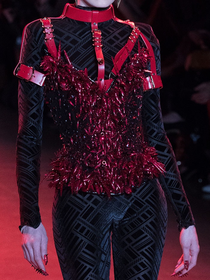 Glittery red-spiked corset and matching nails.