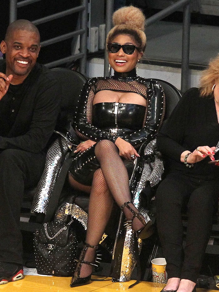 Nicki Minaj in leather, spikes, fishnets, and spiked pumps and carrying a Chanel studded leather backpack.