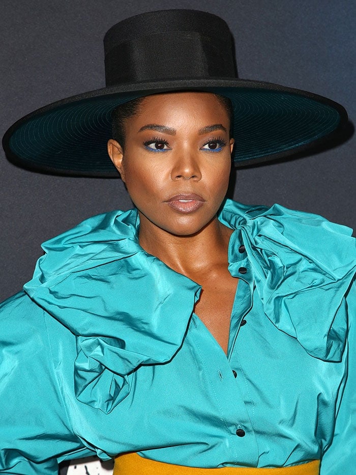 Gabrielle Union in a Marc Jacobs top hat and blue ruffled blouse.
