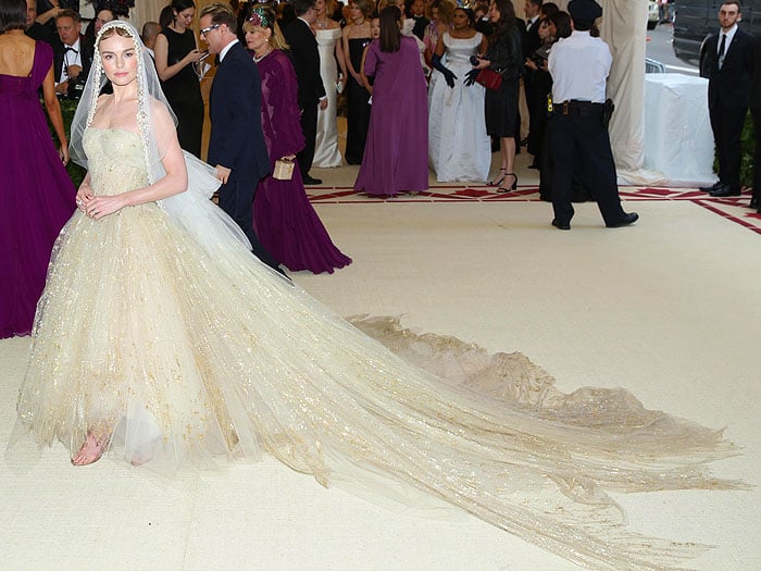 Kate Bosworth in a custom Oscar de la Renta gold-painted tulle gown and veil at the 2018 Met Gala.
