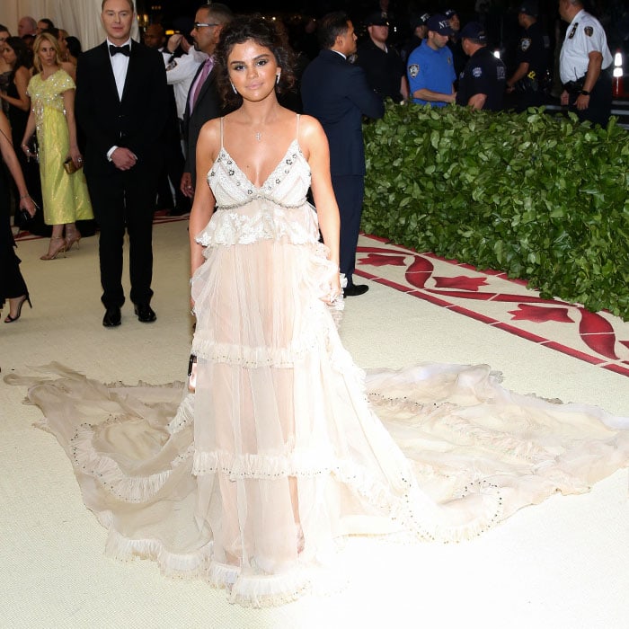 Selena Gomez in a custom Coach vintage silk-gauze gown with a long train and silver custom Coach ankle-strap sandals.