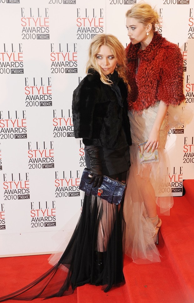 Ashley Olsen (R) exuded timeless elegance in a vintage Christian Lacroix gown, paired with a vintage clutch, Fendi platform shoes, and Bulgari jewels, while Mary-Kate Olsen (L) chose a classic black Lanvin outfit, complemented by a Proenza Schouler clutch and Bulgari jewelry