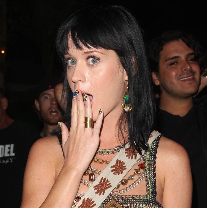 Katy Perry adds a playful touch to her boho-chic Coachella look with a bold, colorful manicure that perfectly complements her statement accessories
