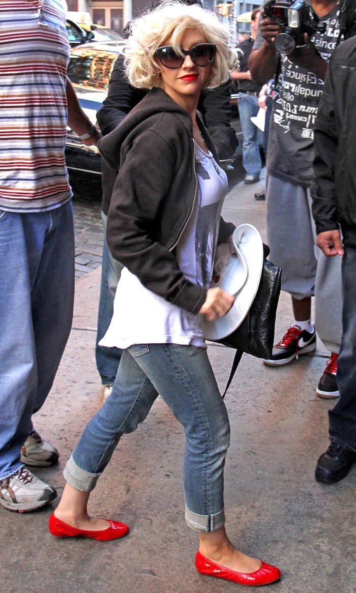 Christina Aguilera elevated her casual denim look with a pop of bold color, pairing cuffed jeans with vibrant red leather Lanvin ballet flats for an effortlessly chic street-style moment