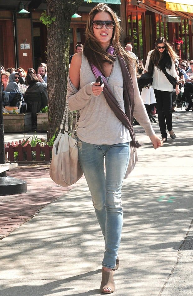Alessandra Ambrosio was seen sporting a laid-back look, wearing a pair of jeans and a tank top, adding a touch of elegance to her outfit with a dip-dyed, thin purple scarf