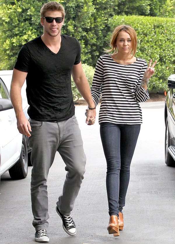 Miley Cyrus wearing high-heeled clog shoes and holding hands with her Liam Hemsworth in Toluca Lake, Los Angeles, on June 8, 2010