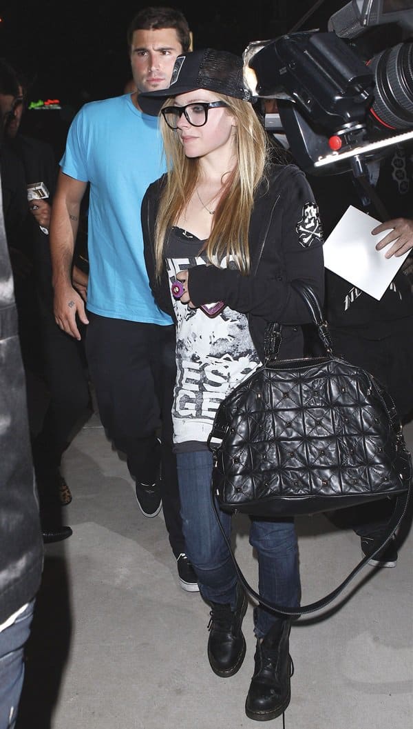 Avril Lavigne completes her punk-inspired look with lace-up combat boots, skinny jeans, and a quilted black satchel while out in Los Angeles with Brody Jenner