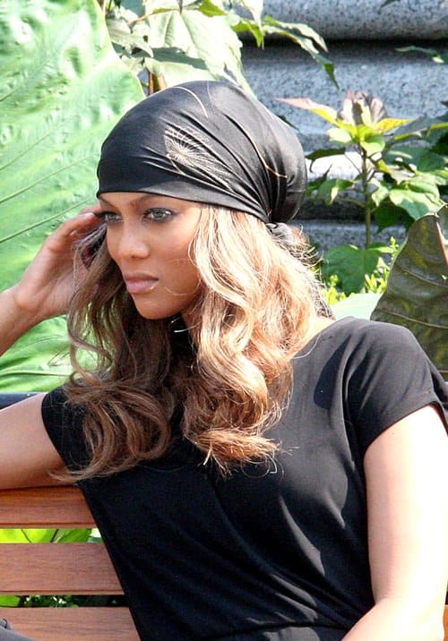 Tyra Banks wears a headscarf while talking on her cell phone