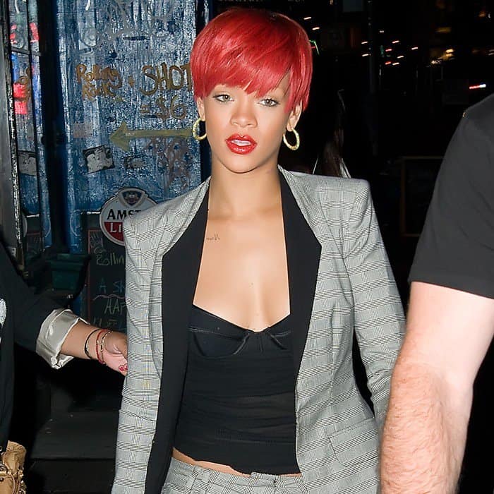 Rihanna sported red hair with a black top and cropped pantsuit