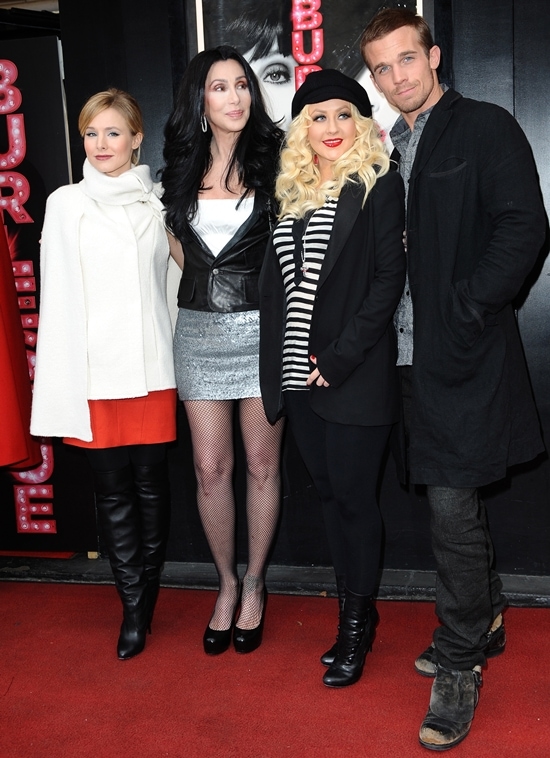 Kristen Bell alongside Cher, Christina Aguilera, and Cam Gigandet in Paris, effortlessly wearing her Vanessa Bruno cape at the Burlesque photo call, December 15, 2010