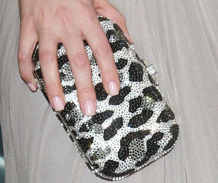 Khloe Kardashian complements her look with Judith Leiber's chic leopard-spot minaudière clutch
