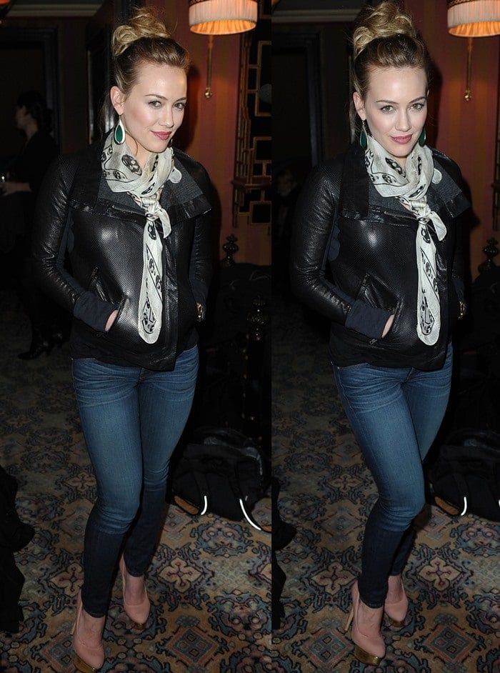 Hilary Duff keeps things casual with a messy bun, patterned scarf, leather jacket, jeans and Charlotte Olympia pumps