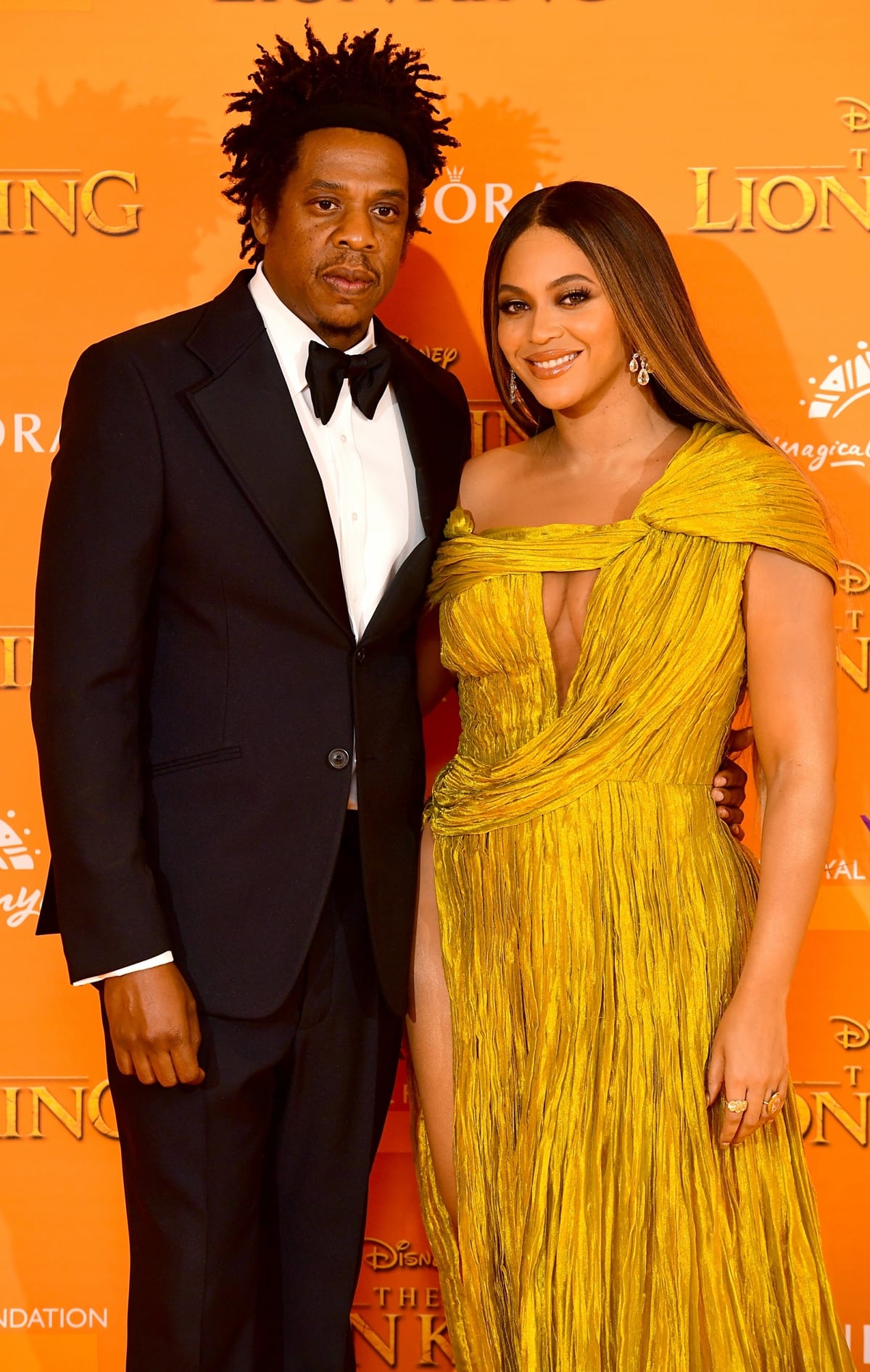 Beyoncé stuns in a gold pleated gown while Jay-Z looks dapper in a classic tuxedo at the premiere of The Lion King