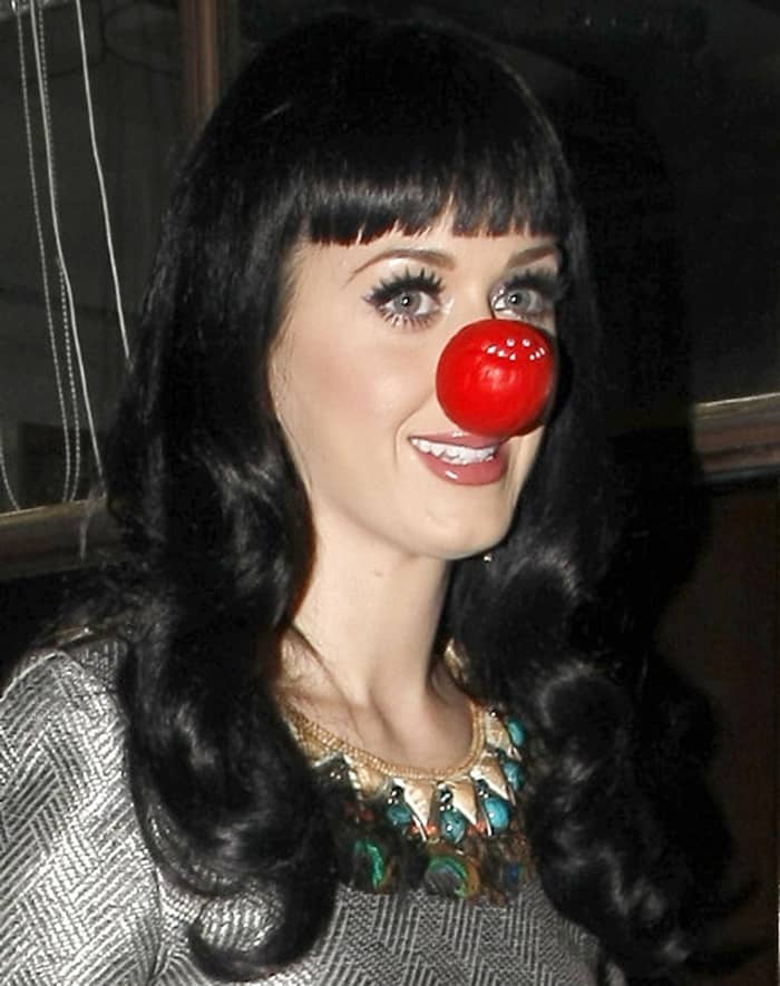 Katy Perry playfully dons a whimsical expression while sporting a vibrant red nose