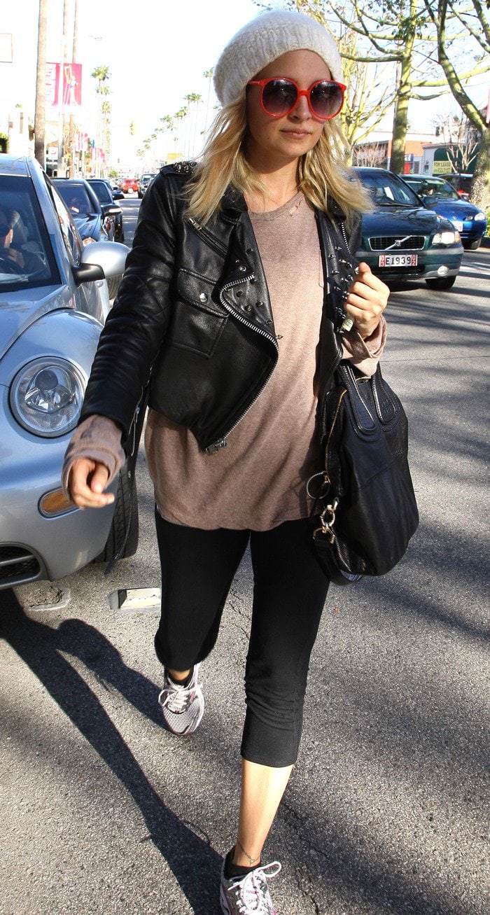 Nicole Richie exudes trendsetting flair leaving the gym, adorned in retro red sunglasses, a stylish beanie, an edgy leather jacket, and the iconic Givenchy 'IT' bag in Los Angeles, California, on February 17, 2011