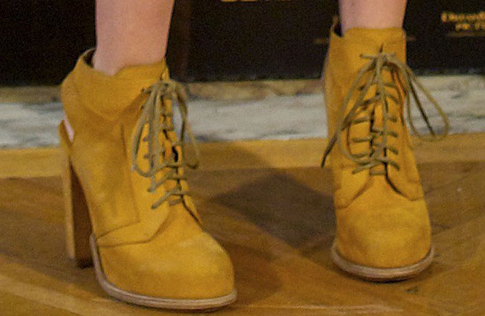 Teresa Palmer elevates her look with Alexander Wang's Dakota lace-up nubuck booties, featuring a bold mustard hue and a sleek, stacked heel