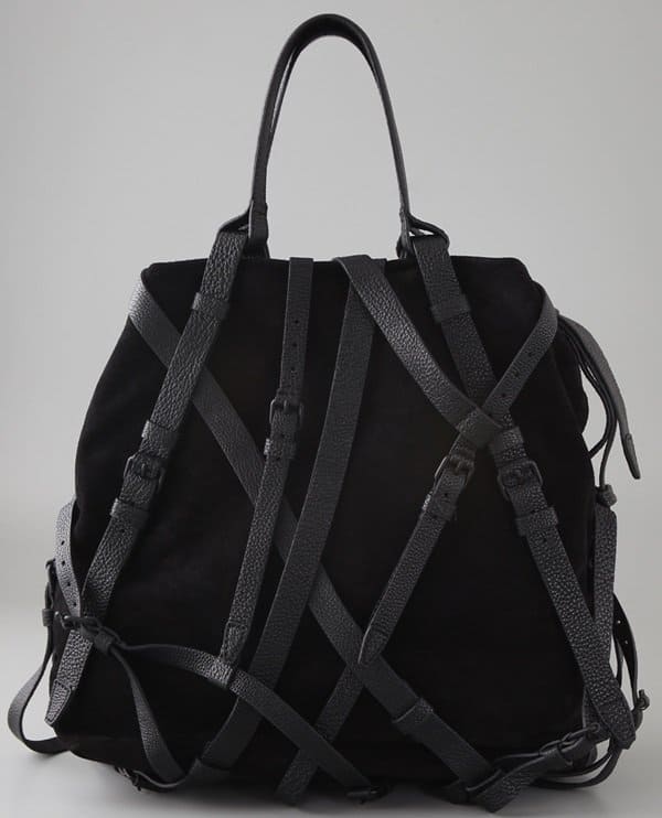The Alexander Wang 'Kirsten' suede tote showcases crisscross pebbled leather straps with buckles, complemented by matte black hardware and pebbled leather handles