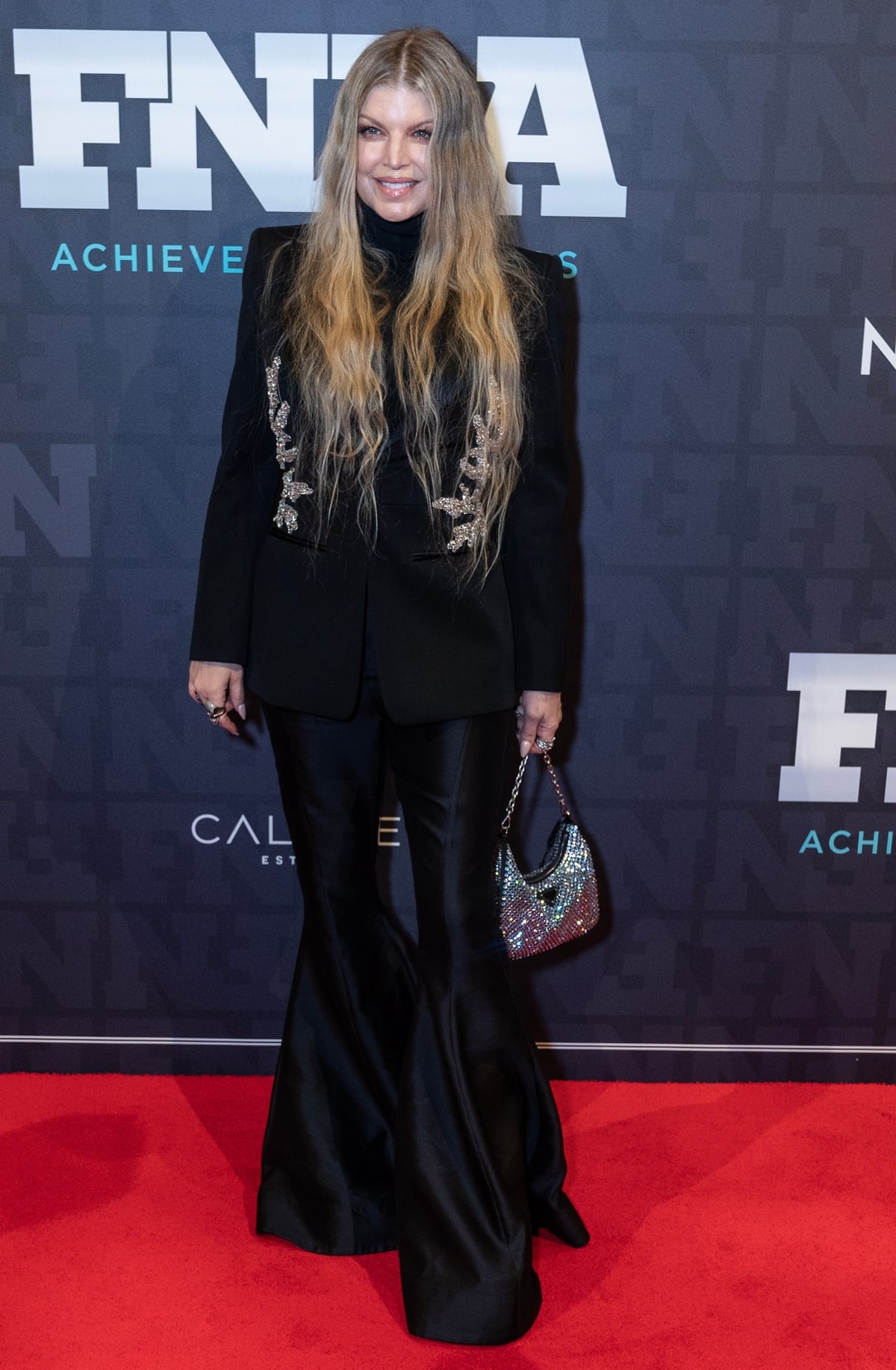 Stacy Ferguson, standing at 5 feet 2 ½ inches (158.8 cm), graced the 2022 Footwear News Achievement Awards held at Cipriani South Street in New York City on November 30, 2022