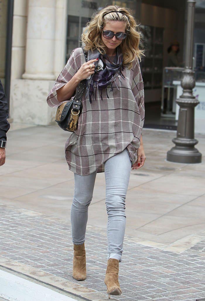 Heidi Klum styled her skull-decorated scarf with jeans, high heel ankle boots, and a plaid shirt