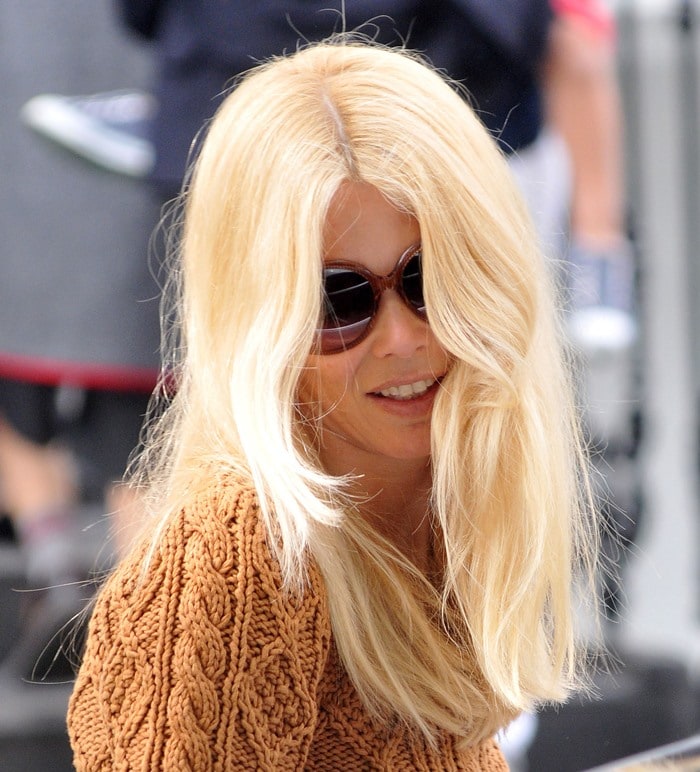 Claudia Schiffer effortlessly exudes chic style in a cozy cable-knit sweater and oversized sunglasses
