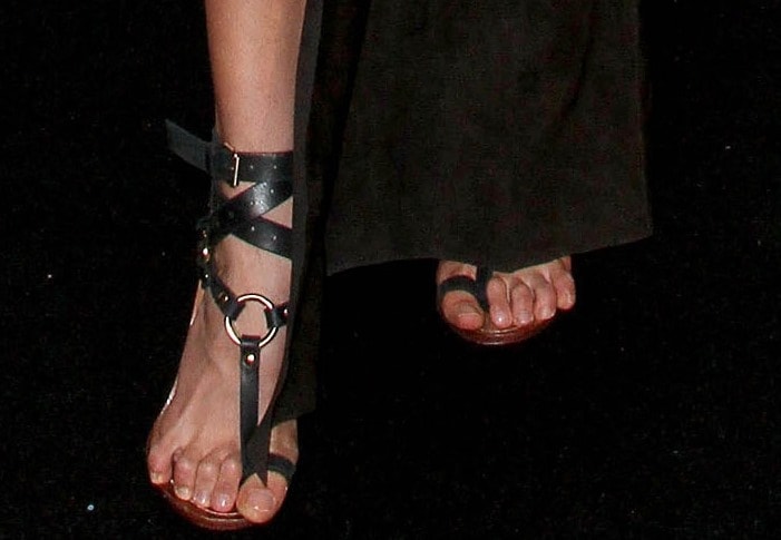 Karolina Kurkova shows off her polished pedicure in Emilio Pucci’s crisscross ankle strap thong sandals, featuring bold ring detailing and high-gloss leather that wraps elegantly around the ankle