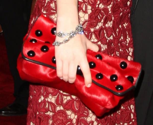 Emily Browning toted a red and black polka dot clutch