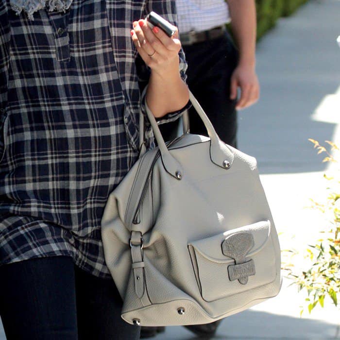 A close-up of Jessica Alba carrying a chic beige Loewe May bag