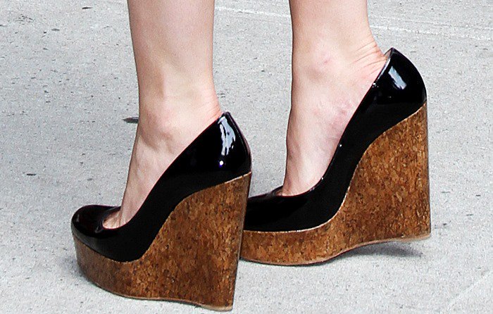 Emma Watson boosts her height by wearing black patent "Coroclic" cork wedge pumps