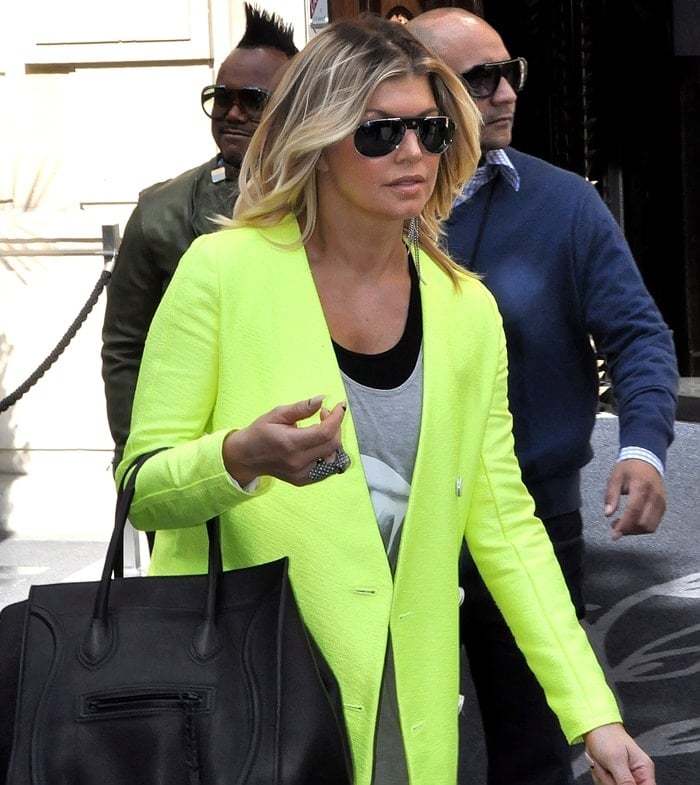 Even under the shade, Fergie's neon green jacket stands out with its vivid hue and sleek design, proving she's a fashion force to be reckoned with