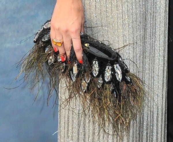 A detailed glimpse into Olivia Palermo's fashion choice: the romantic and vintage-inspired feather clutch