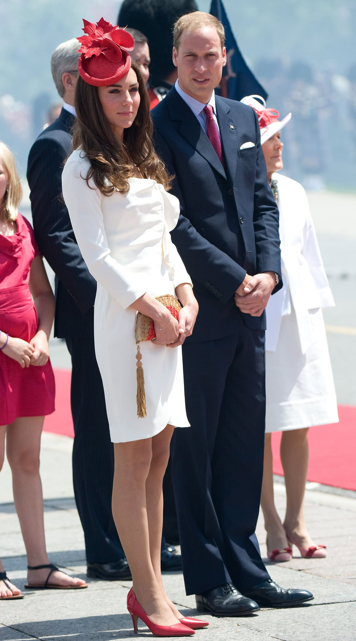 Pair bold red pumps with a neutral outfit like Kate Middleton's white dress to create a striking, elegant contrast that highlights the shoes as a statement piece