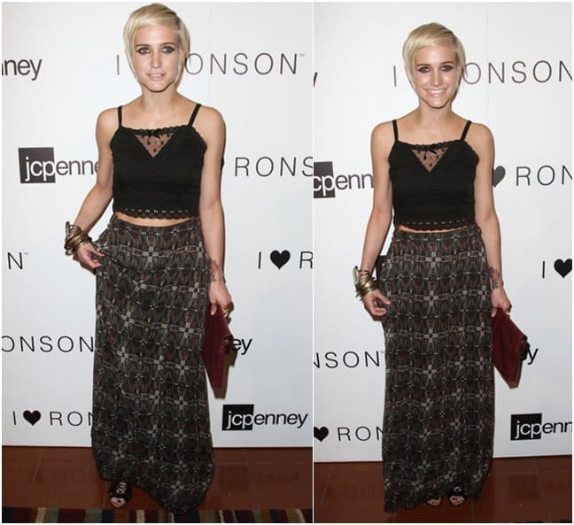 Ashlee Simpson pairs a high-waisted printed maxi skirt with a cropped black cami, accessorizing with stacked bangles, a red clutch, and black open-toe sandals for a laid-back yet stylish look