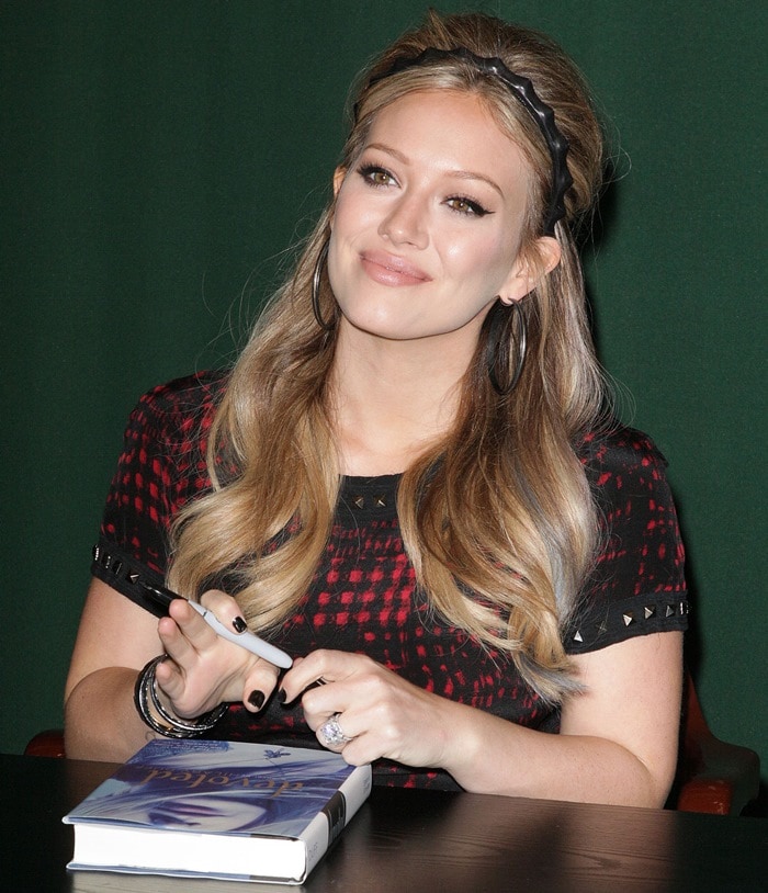 Hilary Duff poses for pictures and signs copies of her new book "Devoted"