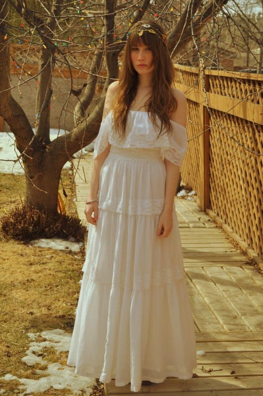 Amy Nelson in her favorite dress—her mother’s ethereal graduation gown from the 1970s—styled with a faux fur vest and platform heels for a romantic, vintage-inspired look