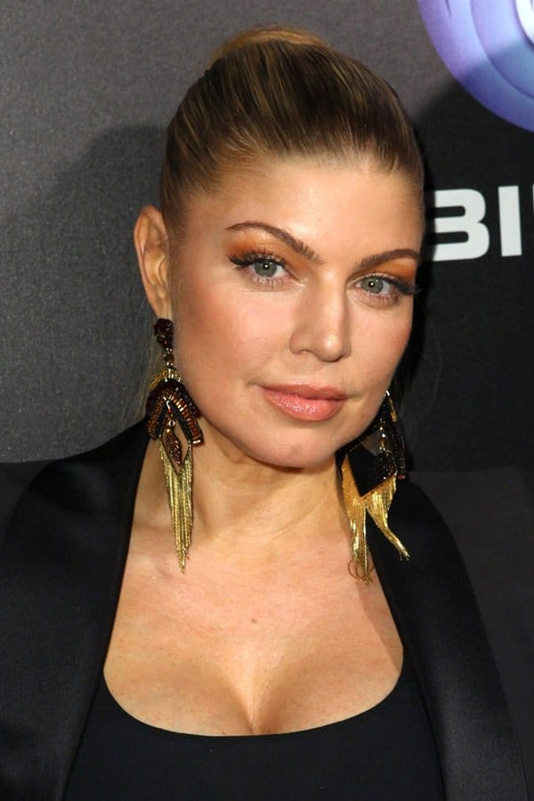 Fergie completes her bold look with statement gold and black chandelier earrings