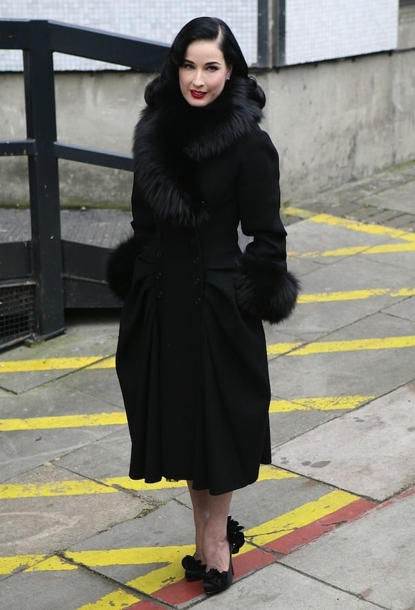 Dita Von Teese wears a fur-trimmed winter coat while out in London