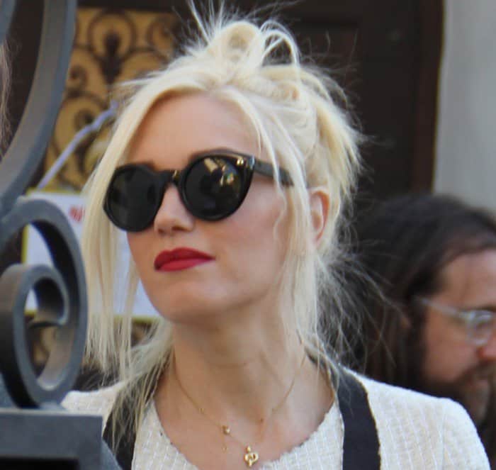 Gwen Stefani pairs her edgy updo with bold red lips and chic Cutler & Gross 0734 keyhole sunglasses