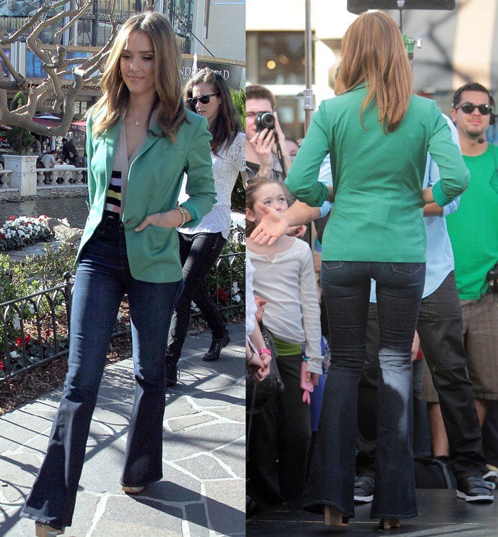 Jessica Alba wears a green Lisa Ho blazer and a pair of flared jeans for an appearance on "Extra"