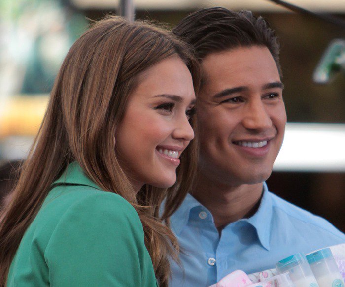 Jessica Alba and Mario Lopez pose for photos together on the set of "Extra"