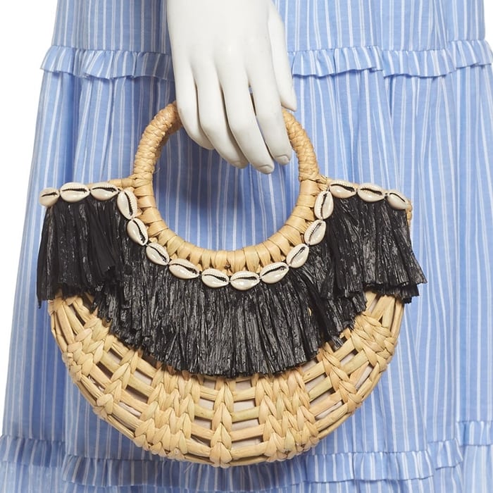 Cowrie shell and raffia trim add fun, festive touches to a woven straw handbag that channels carefree vacation vibes