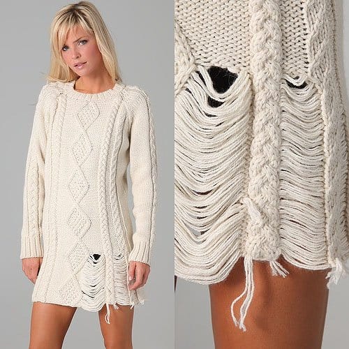 This crew-neck, cable-knit sweater dress features shredding at the bottom hem