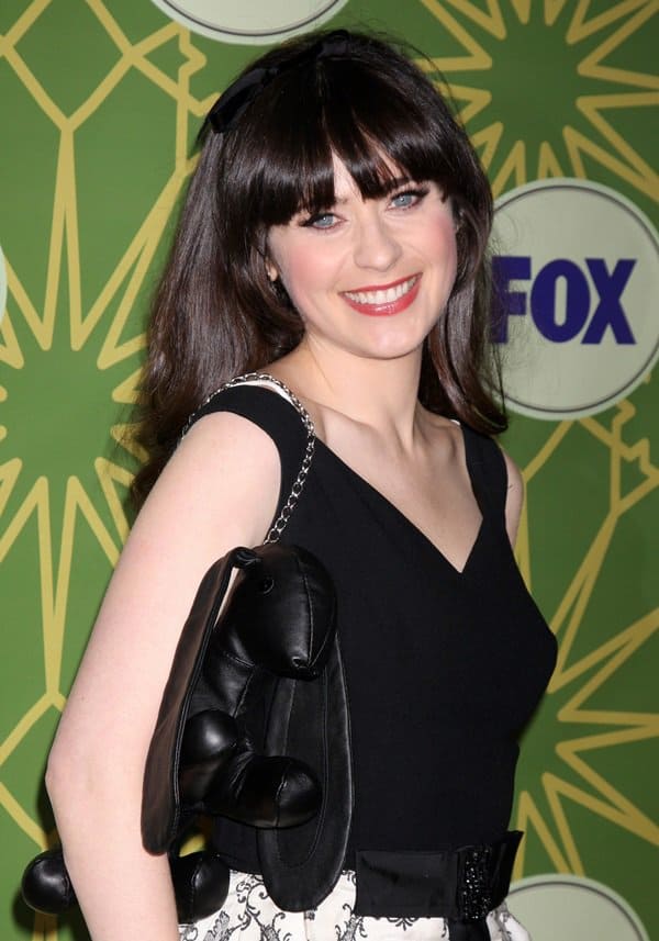 Zooey Deschanel accessorizes with Mandy Coon's whimsical leather purse, adding a touch of fun to her ensemble