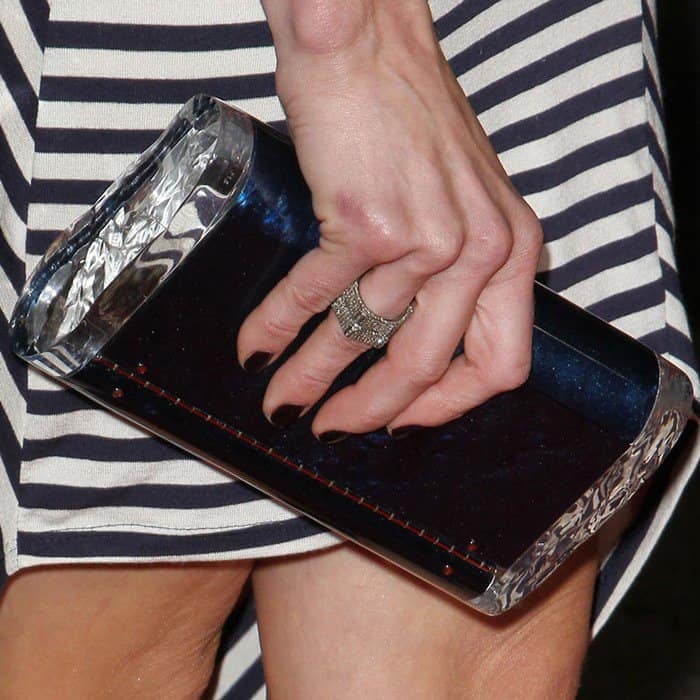 Elevating a simple striped dress to Hollywood glamour, Chelsea Handler pairs it with a shiny navy and silver box clutch